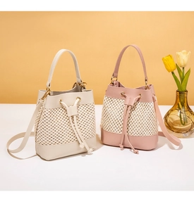 Detail showing woven bucket bags with leather trim and drawstring closure in beige and pink