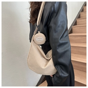 Détail du sac croissant en velours côtelé beige avec petit porte-monnaie rond et broderie