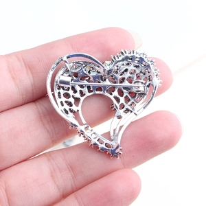 Silver hollow heart-shaped brooch with yellow rhinestones shown from the back
