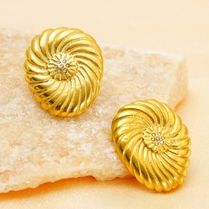 Détail de boucles d'oreilles tournesol spirale dorées 18 carats avec diamants sur soie