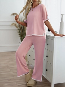 Detailed view of pink short-sleeve knit top and pants with white trim details