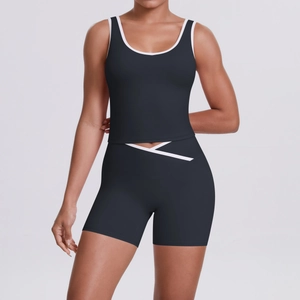 Détail d'un ensemble de yoga noir avec short à taille croisée et bordures blanches