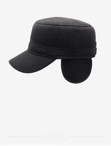 Detail view of thickened wool flat top cap with ear flaps and metal sports badge
