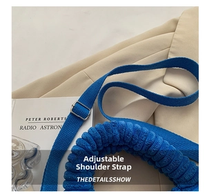 Close-up of the royal blue plush bucket bag showing the adjustable woven strap buckle