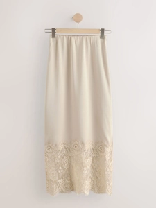 Detail showing delicate lace trim on champagne satin midi skirt hem for women