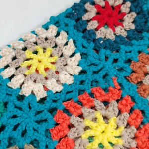 Close-up of vibrant crochet floral patterns and knit texture on this handmade tote bag