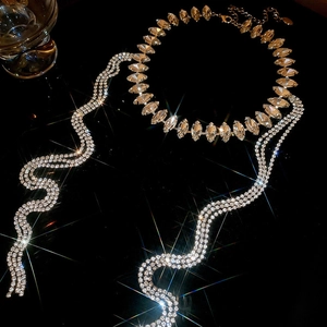 Vue détaillée du collier ras-du-cou en strass et boucles d'oreilles sur fond sombre
