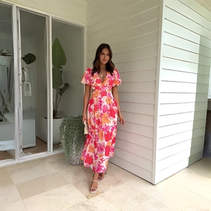 Close-up of pink floral dress featuring V-neckline, puff sleeves, and waist cut-out details