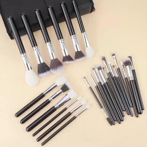 Macro shot of 25 professional makeup brushes with silver ferrules on light background