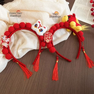 Detail of red festive lion dance headband with plush pom-poms and lucky tassels