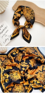 Detail of silk scarf with vintage gold baroque patterns and smooth fabric texture