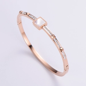 Detail of rose gold bangle with square shell inlay, pave crystals and pyramid studs