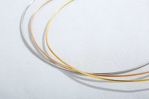 Detailed view of polished stainless steel collars in silver, gold, and rose gold finishes