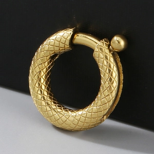 Macro view of golden round metal clasp with textured rhombus pattern and polished finish
