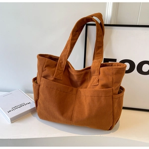 Gros plan sur le sac fourre-tout en velours côtelé caramel montrant la texture côtelée
