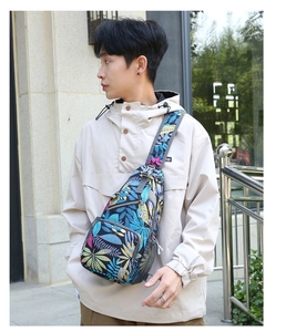 Detailed view of leaf-patterned crossbody bag featuring multi-zippered pockets on a model