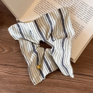Detail of vintage striped scrunchie with golden heart charm on an open book