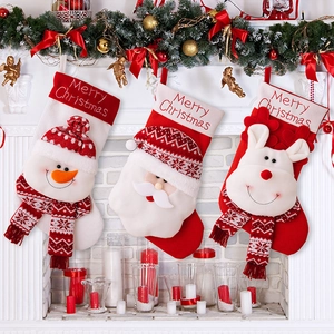 Hanging Christmas stockings with 3D snowman, Santa, and reindeer plush toys on a fireplace
