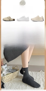 Detailed knit texture of grey crew socks with embroidery bow accents for women