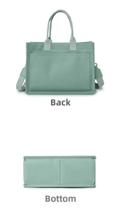 Detail view of mint green canvas tote bag showing back pocket and reinforced bottom base