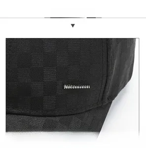 Detail of black checkered baseball cap with silver metal plaque and textured fabric