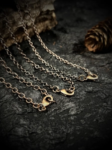 Vintage bronze link chains for pendants and sweaters with lobster clasp on a dark background