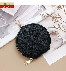 Detail of black leather coin purse with litchi texture and gold zipper hook