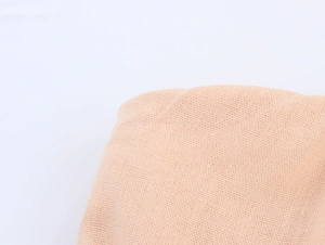 Dettaglio macro della trama del tessuto a maglia beige traspirante per abiti