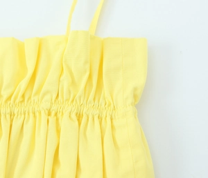 Detail eines gelben Crop-Tops mit elastischem gerafftem Stoff und Schultergurt-Design