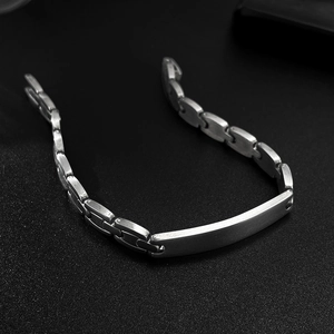 Macro shot of polished stainless steel curved plate and link chain on a dark background