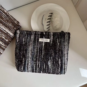 Minimalist black and blue tweed cosmetic bag with Simple Wish label on white setup
