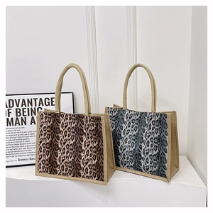 Detailed view of leopard print linen tote bags in brown and grey with PU leather handles