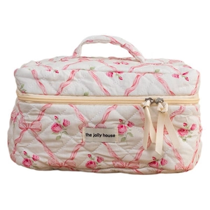 Quilted floral makeup bag with pink roses, bow patterns, and a sturdy handle