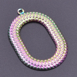 Macro shot of oval textured metal pendant with iridescent rainbow finish and ring