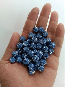 Macro shot of 10mm dark blue sparkling Shamballa crystal beads on hand for jewelry making
