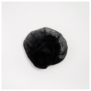Macro detail of layered black 3D rose brooch made of sheer organza mesh fabric
