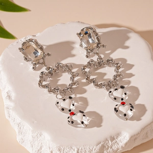 Luxe silver needle earrings featuring large crystals and polka dot resin heart charms