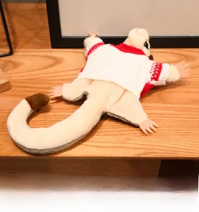 Close-up of a sugar glider plush toy wearing a red and white knitted Nordic sweater