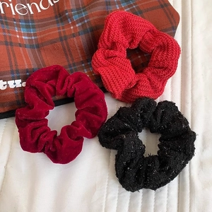 Three-piece knitted and velvet scrunchies set in red, burgundy, and textured black colors