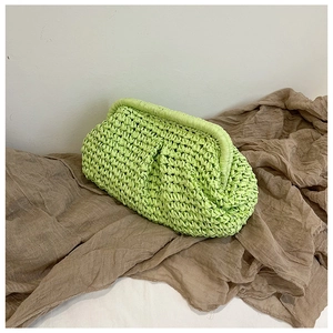 Macro view of woven paper rope texture on a neon green dumpling-style shell clutch bag