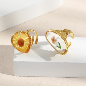 Detail showing vintage resin rings with real dried flowers on golden metal stands