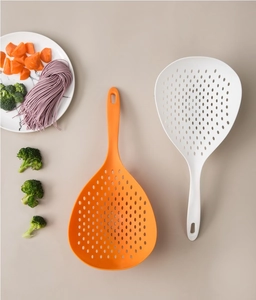 Macro view of long-handle nylon noodle strainers in orange and white for draining pasta
