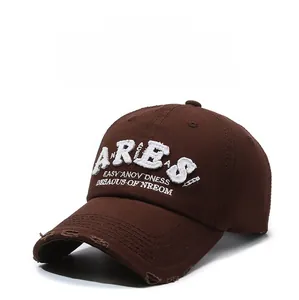 Detail of distressed brim and white Aries embroidery on washed cotton baseball cap