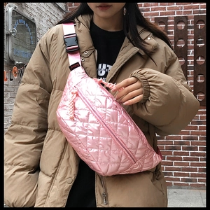 Pink quilted crossbody waist bag with metallic finish shown on model in street setting