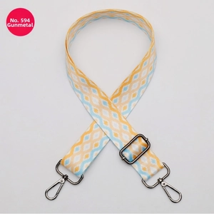 Detail of adjustable gunmetal buckle on geometric diamond pattern bag strap