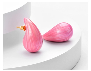 Macro shot of pink marble texture drop earrings on a white geometric display stand