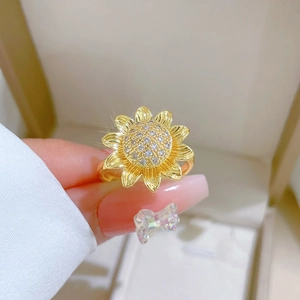 Detailed macro view of golden sunflower ring featuring layered petals and sparkling zircons