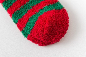 Close-up of thick red and green striped coral fleece Christmas socks with soft texture
