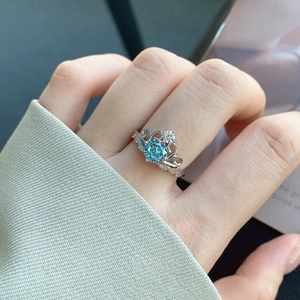 Detail of S925 sterling silver ring with blue zircon in a crown setting on finger