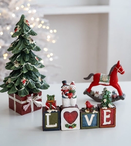 Detailed view of resin Christmas decor featuring rocking horse and festive LOVE letter blocks